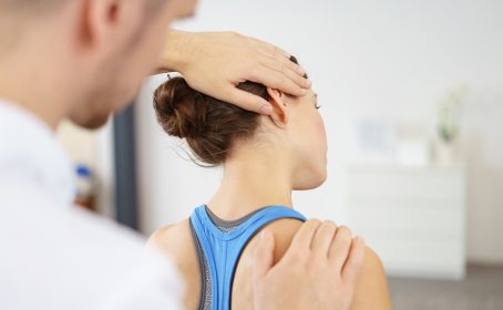 physiotherapeut behandelt eine patientin mit nackenschmerzen